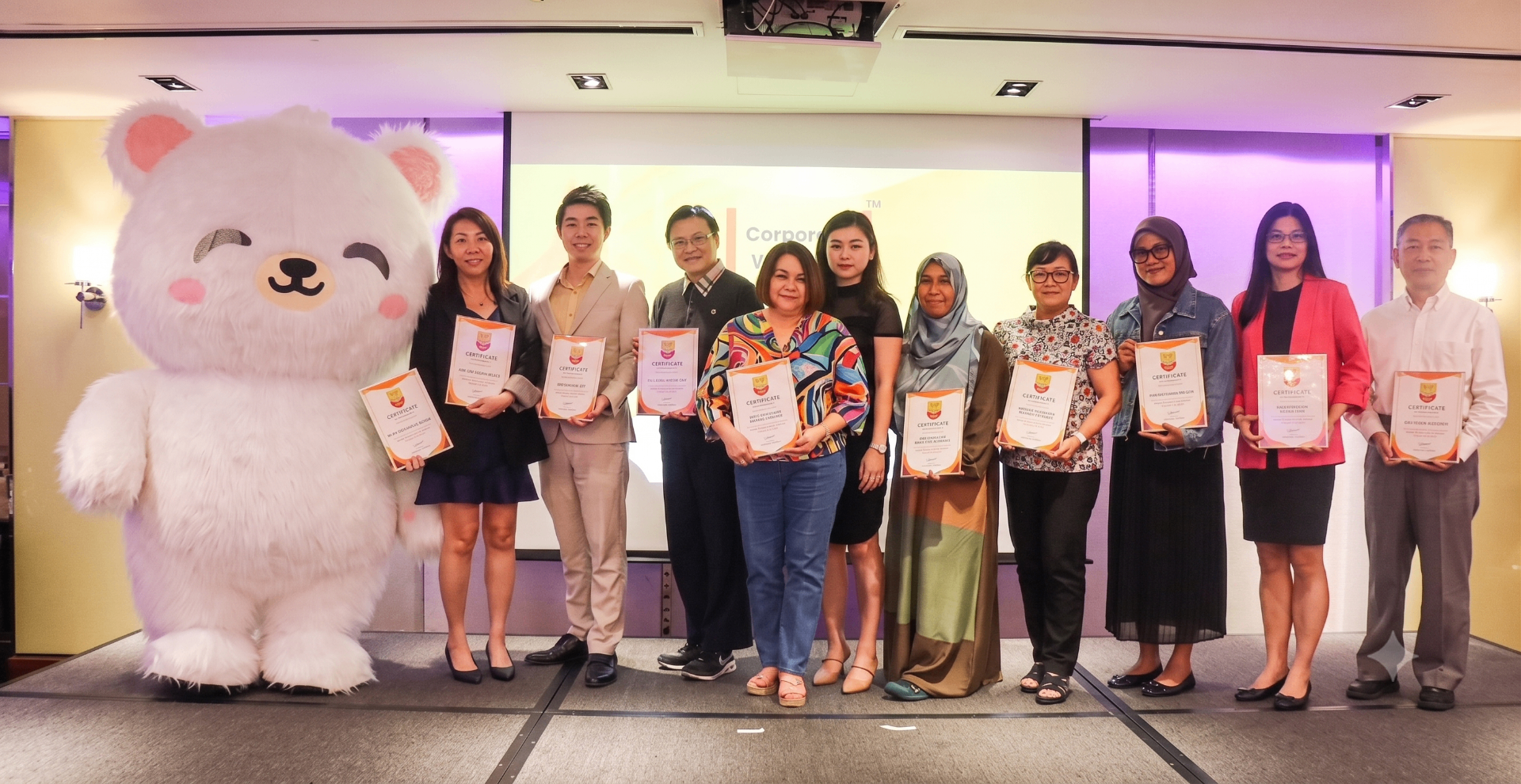 Corporate Wellness Champions cohort graduates holding their certificates with the Aventis mascot